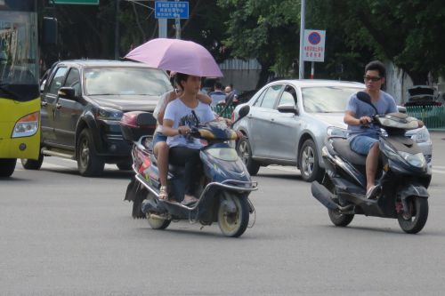 莆阳路与八二一街交叉处，一女子坐在电动车后座打伞，也存安全隐患