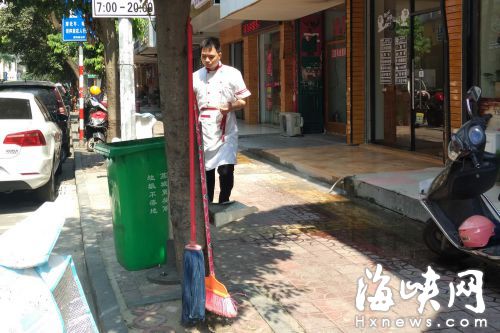 东大路上，有店家在行道树上钉钉子挂拖把等杂物