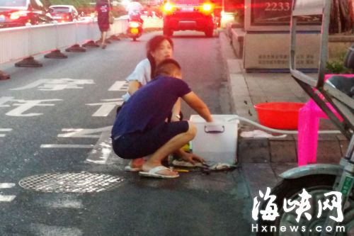 ﹃忆味小龙虾﹄员工在路旁雨水井杀鱼